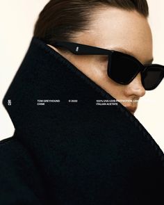 a woman wearing sunglasses and a black coat with the words tom ford written on it