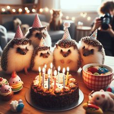 three hedgehogs sitting in front of a birthday cake with lit candles on it