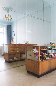 an empty dressing room with mirrored walls and wooden furniture in front of the mirror wall