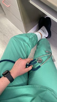 a person with a stethoscope laying on the floor next to a desk