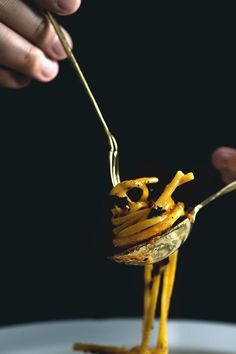 a person is holding a fork with some food on it in the shape of a bird