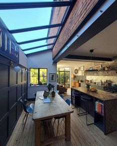 an open kitchen and dining room area with skylights above the counter top, along with wooden flooring