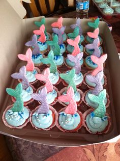 cupcakes in the shape of mermaid's tails are displayed on a tray