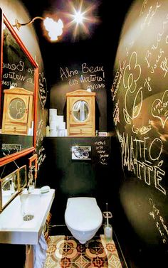 a bathroom with chalk writing on the walls