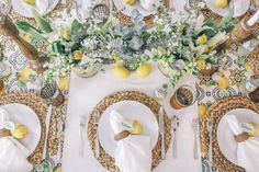 the table is set with plates, napkins and flowers