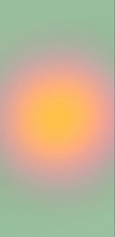 an orange and yellow circle is in the middle of a blurry background with green