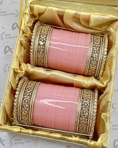 two pink cups in a box with gold trimmings on the edges and sides