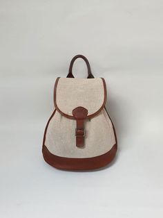 Editor's NotesGONI atelier presents classic accessories that are practical and convenient to use in your daily life. - Leather and canvas combination- Buckle and magnetic closure- Drawstring detail- Open pocket at interior- Classic and casual mood Measurements (in.)One Size- Size: 13.39 in. (W) * 9.84 in. (H) * 7.28 in. (D) - Strap: 29.13 ~ 34.25 in. (H) Composition & Care- Material: Cow Leather (Italy), Linen Cotton Canvas- Natural leather may have fine scratches and wri Classic Coated Canvas Backpack With Leather Trim, Classic Backpack With Leather Trim For Daily Use, Classic Daily Use Backpack With Leather Trim, Everyday Leather-trimmed Coated Canvas Backpack, Classic Beige Backpack For Everyday Use, Beige Backpack With Leather Trim For Everyday Use, Classic Everyday Coated Canvas Backpack, Classic Coated Canvas Leather Backpack For Everyday Use, Everyday Beige Backpack With Leather Trim