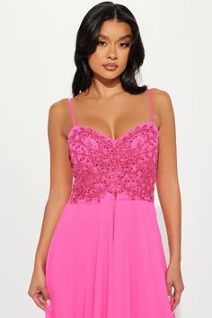 a woman wearing a bright pink dress with sequins on the bust and straps