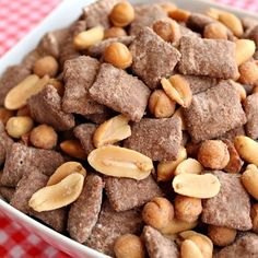 a white bowl filled with brownies and nuts on top of a checkered table cloth