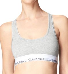 This soft bra offers light support and features the repeating Calvin Klein logo on the elastic underband. Wireless cups are lined with same fabric for gentle support. Elastic underband provides additional support and has the repeated Calvin Klein logo. Tall center front. Sewn-on elastic along top and bottom of sides for custom fit. Non-adjustable straps. Racerback for movement - great to wear under sleeveless tops. Pullover styling. Please Note: "Unlined" means that cups are unpadded. Calvin Kle Calvin Klein Bras, Calvin Klein Bra, Cotton Bralette, Comfy Bra, Soft Bra, Sleeveless Tops, Wireless Bra, Calvin Klein Woman, Bra Lingerie