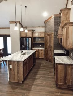 a large kitchen with wooden cabinets and marble counter tops