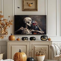 a living room decorated for halloween with pumpkins and skeleton decorations on the sideboard