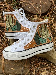 Hand tooled cacti design on quality 4-5 oz vegetable tanned leather with white buckstitching. Hand sewn. These are the high top Chuck Taylor All Star platform shoes in White, size 7. *All shoe sales are final. Leather Tooled Shoes, Rodeo Nails, All Star Platform, High Top Chucks, Country Shoes, Cowgirl Style Outfits, Cowgirl Accessories, Western Shoes, Leather Converse