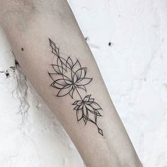 a black and white photo of a woman's arm with a flower tattoo on it