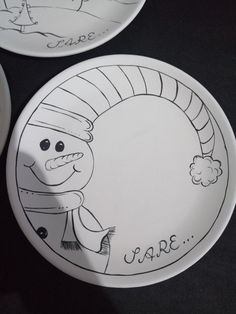 two plates with drawings on them sitting next to each other