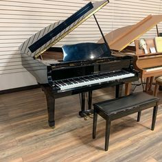 there is a piano and stool in the room with wood flooring on the walls