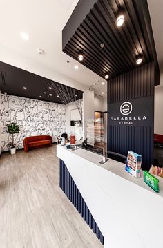 an office lobby with wood flooring and white counter top, along with black and white wallpaper