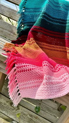 a colorful blanket sitting on top of a wooden bench