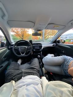 two people laying down in the passenger seat of a car