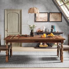 a dining room table with chairs and pictures on the wall above it, along with an area rug