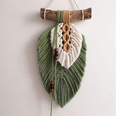 a green and white wall hanging with wood beads