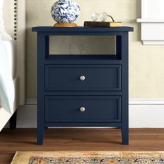 a night stand with two drawers and a blue vase on the end table next to it