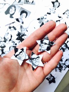 a person's hand is holding four star shaped magnets in front of a black and white photo