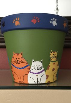 a painted pot with three cats on it