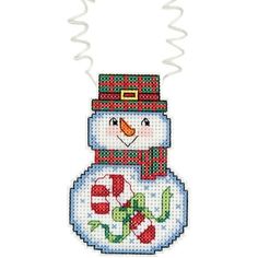 a cross stitch snowman ornament hanging from a string on a white background