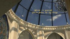 the inside of a building with a large glass dome and writing on it's side