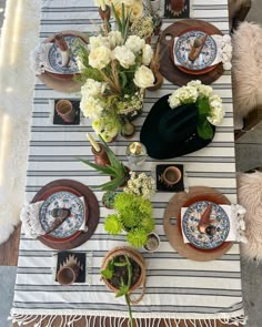 the table is set with plates and flowers