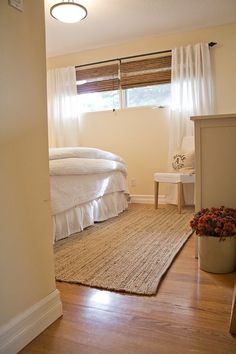 a bedroom with white bedding and wooden floors