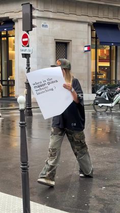 a person walking down the street with a sign in front of them that says,