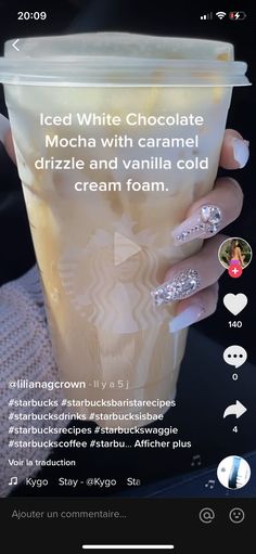 a woman's hand holding up a cup with white chocolate on it and the words iced