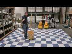 a man standing on top of a checkered floor next to a bucket and mop