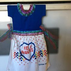 a dress that says help wanted hanging on the wall in front of an oven door