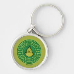 a round keychain with a green and yellow logo on it