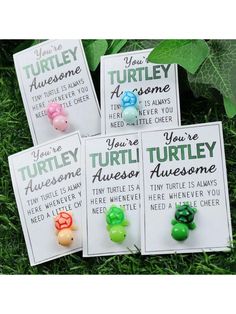 four turtle magnets are sitting in the grass with green leaves around them and one is saying, you're turtles awesome