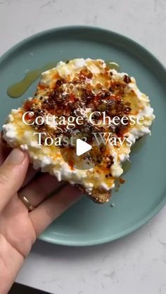 someone is holding a piece of food on a blue plate with the words cottage cheese toast ways