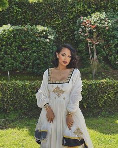 a woman in a white dress standing on grass