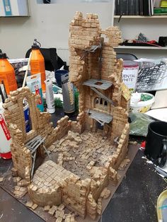 a model of a castle made out of bricks on a workbench in a workshop