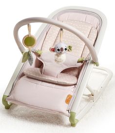 a baby's rocking chair with a stuffed animal in the back and on top