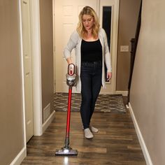 a woman is using a vacuum to clean the floor