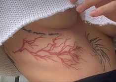 a woman's stomach with tattoos on it and the word love is written in red ink