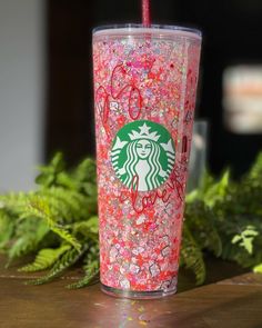 a starbucks cup with pink sprinkles and a red straw in the middle