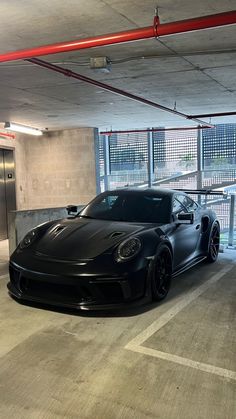 a black sports car parked in a parking garage