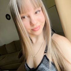 a woman with long blonde hair posing for the camera