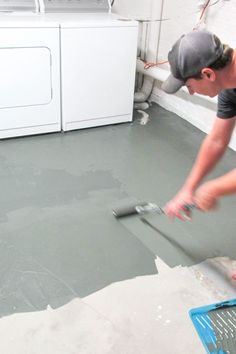 a man is working on the floor in his laundry room