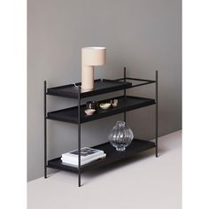 a black shelf with a lamp on top of it